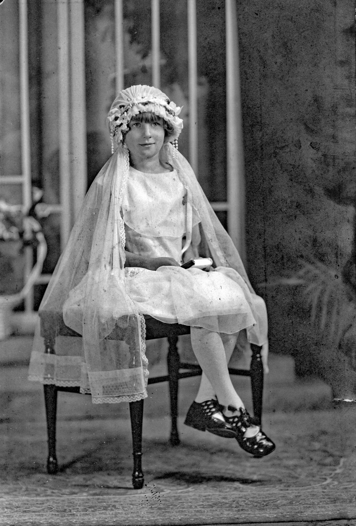 Marion Gratz at her first communion, holding a prayer book, Chicago, Illinois.